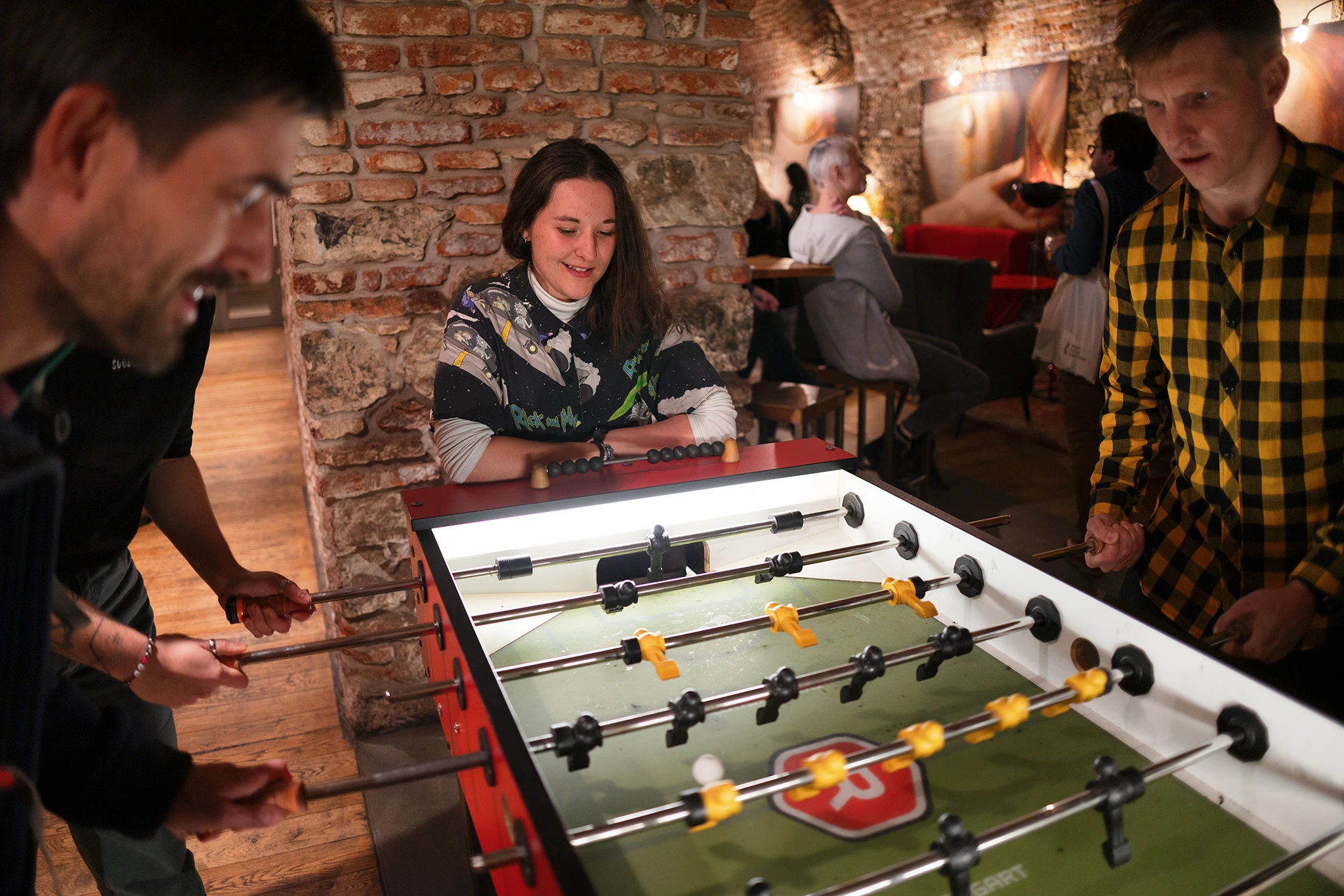 Attendees playing table football, celebration of International volunteer day, Salsita club, Prague, Czech Republic, 2023