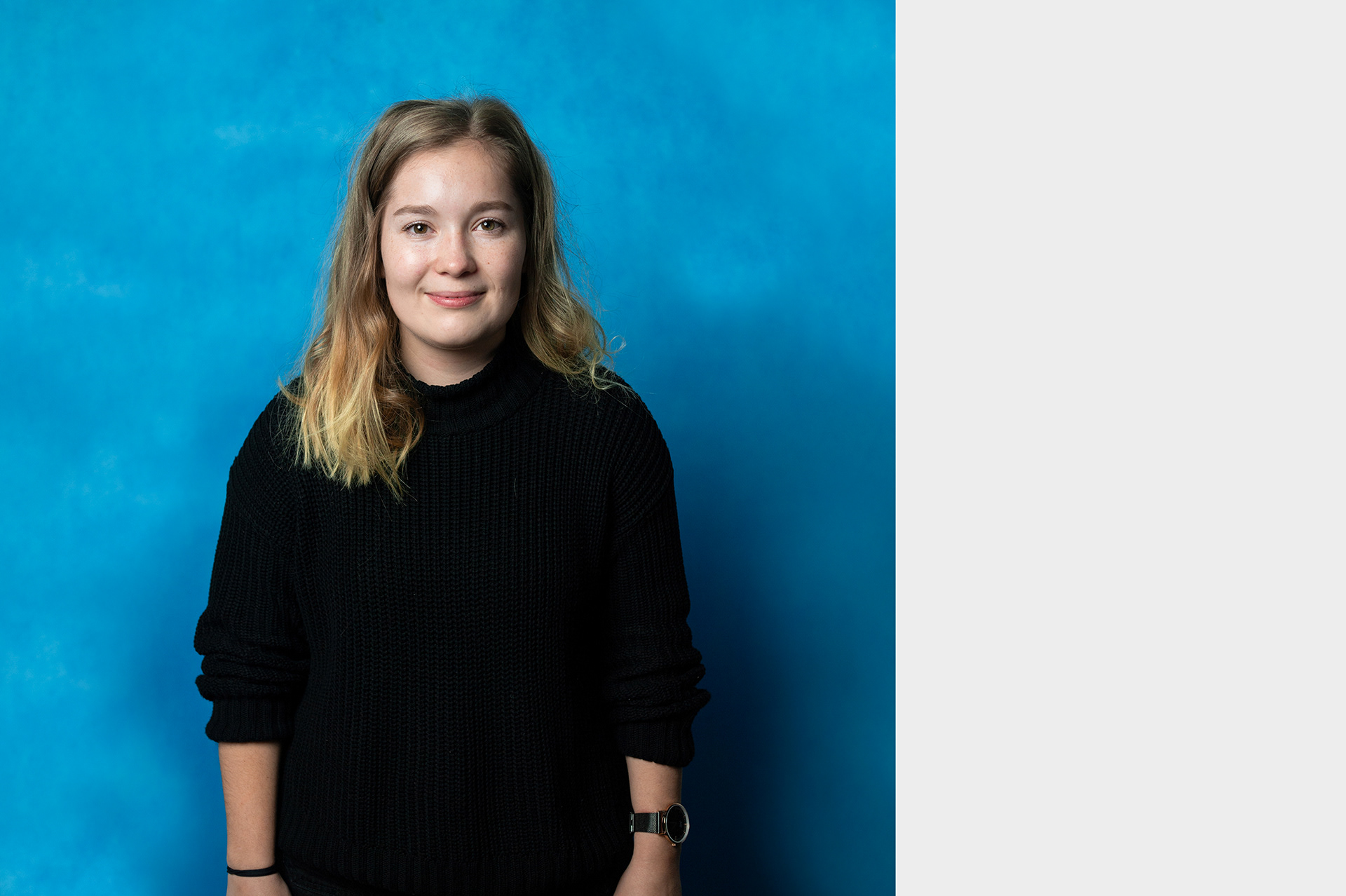 Jana, studio portrait of young female volunteer in front of blue background